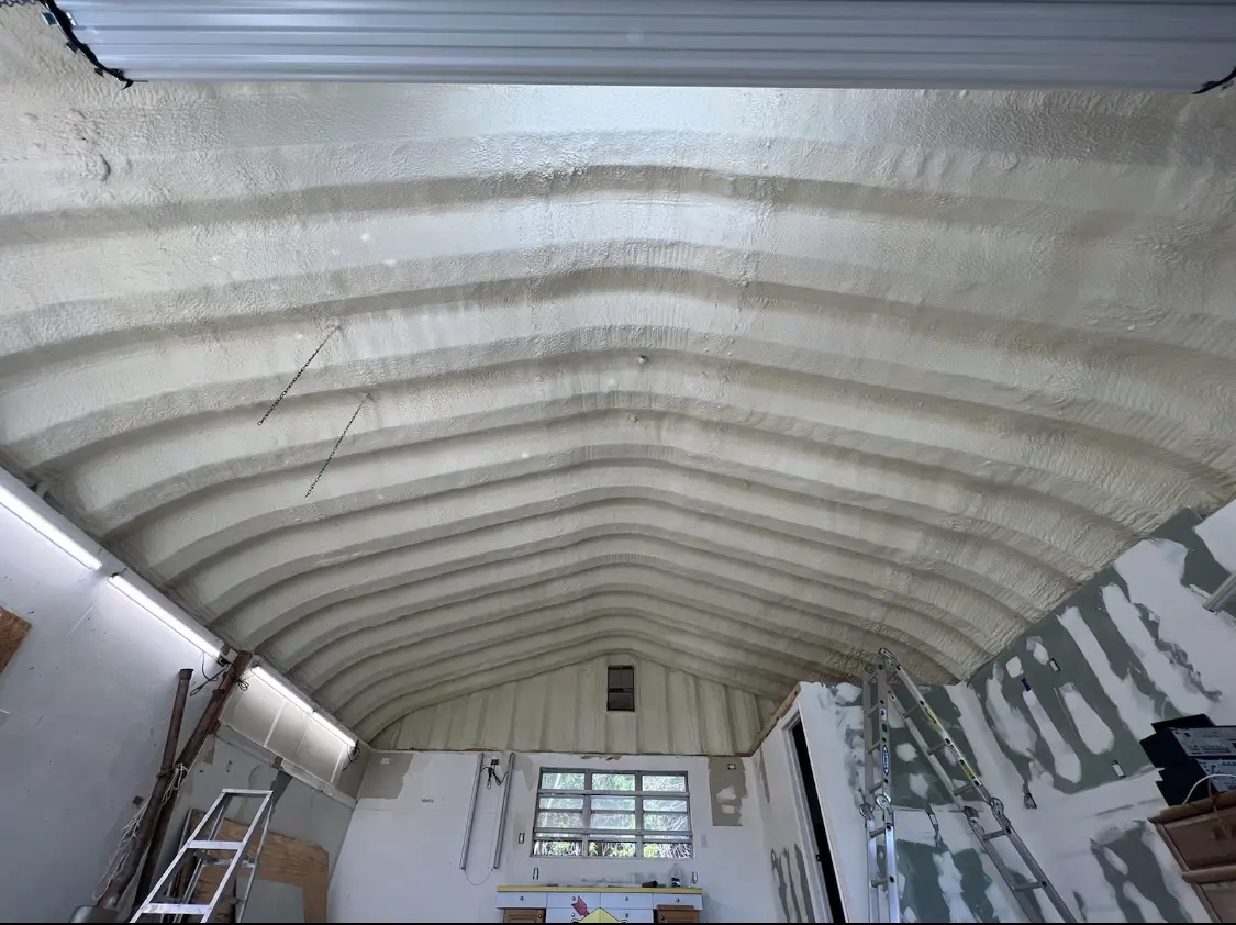 Spray polyurethane foam applied to the underside of a metal roof deck in Logan